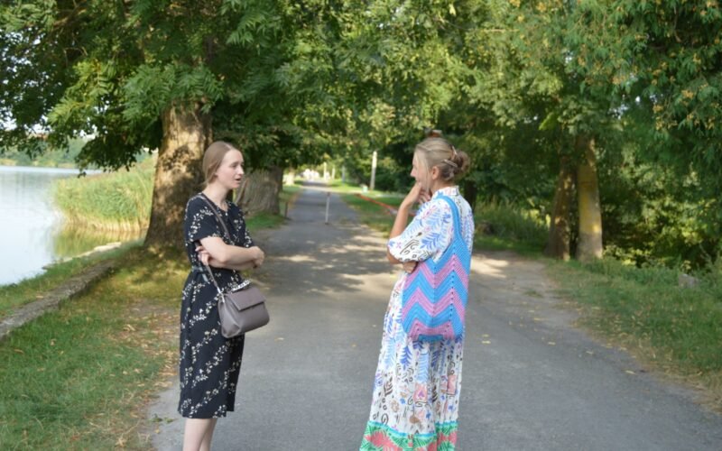 Two women standing on a path talking